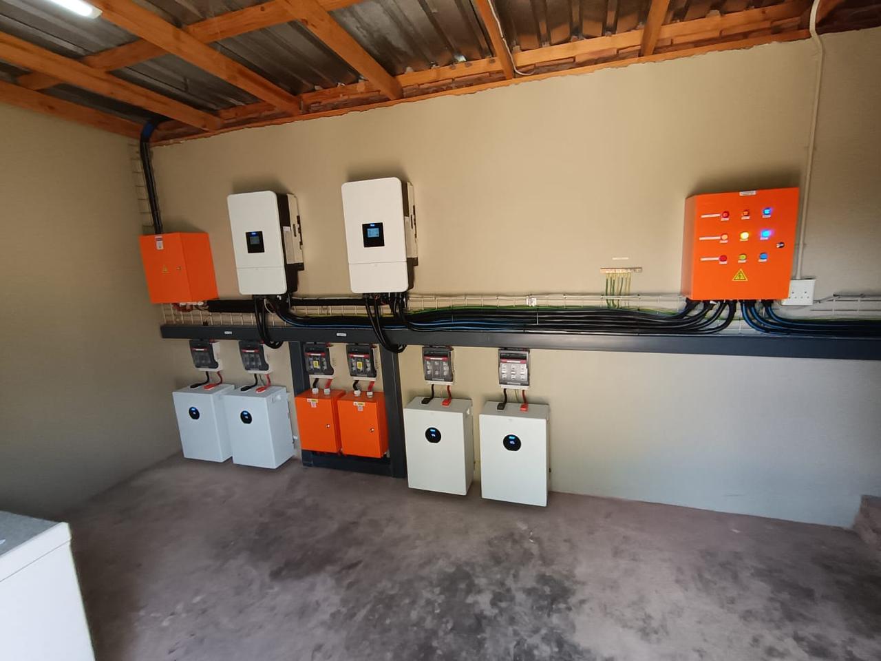 Semcon technician at a residential inverter and battery cabinet